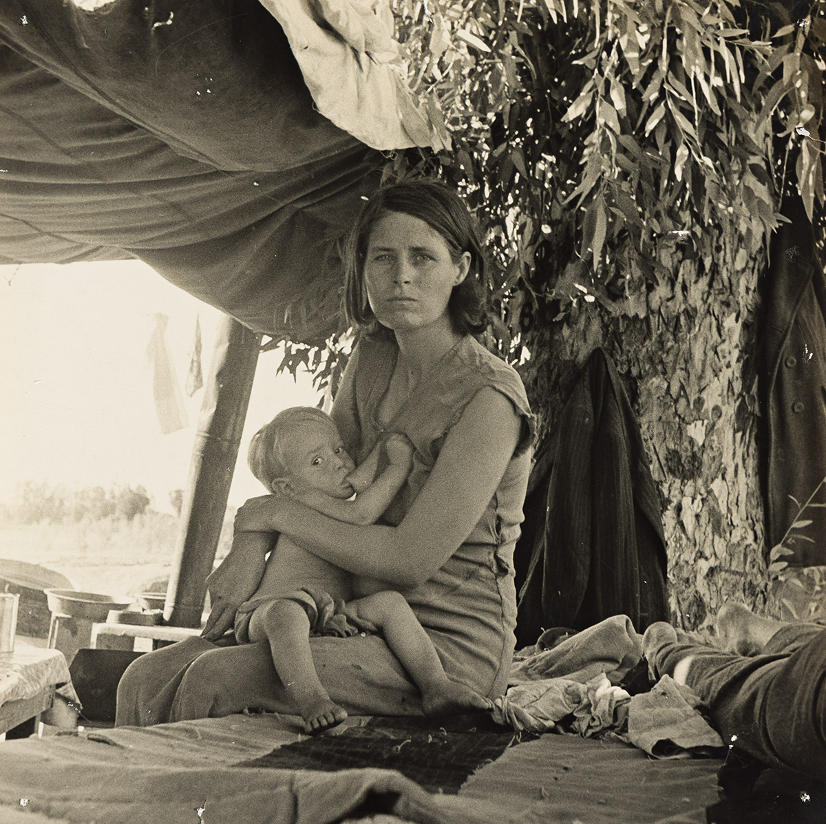 DOROTHEA LANGE (1895-1965) Mother and nursing child, Drought refugees from Oklahoma camping by the roadside, Blythe, California.